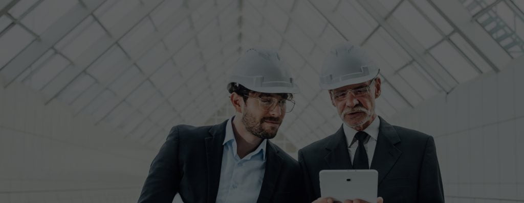 two-successful-entrepreneur-helmet-with-project-laptop-new-buildings-stay-near-glass-roof 1